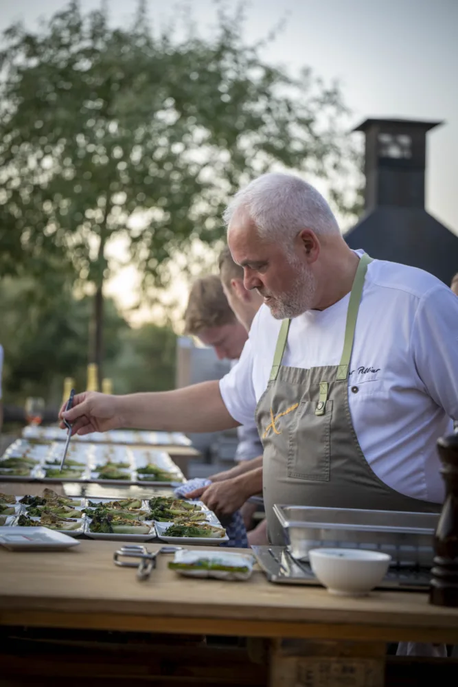 Chef emplatando al aire libre en una cena del Festival Gastronómico