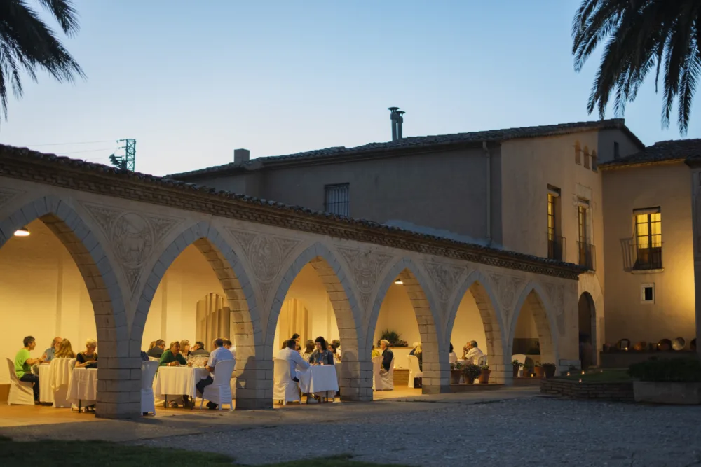 Claustro de una bodega iluminado durante una cena del Festival Gastronómico