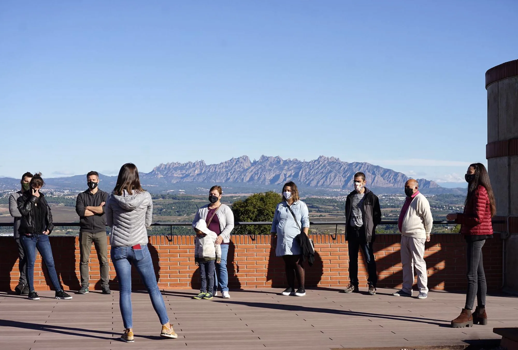 Visitants en una terrassa amb vistes a Montserrat durant la jornada de portes obertes