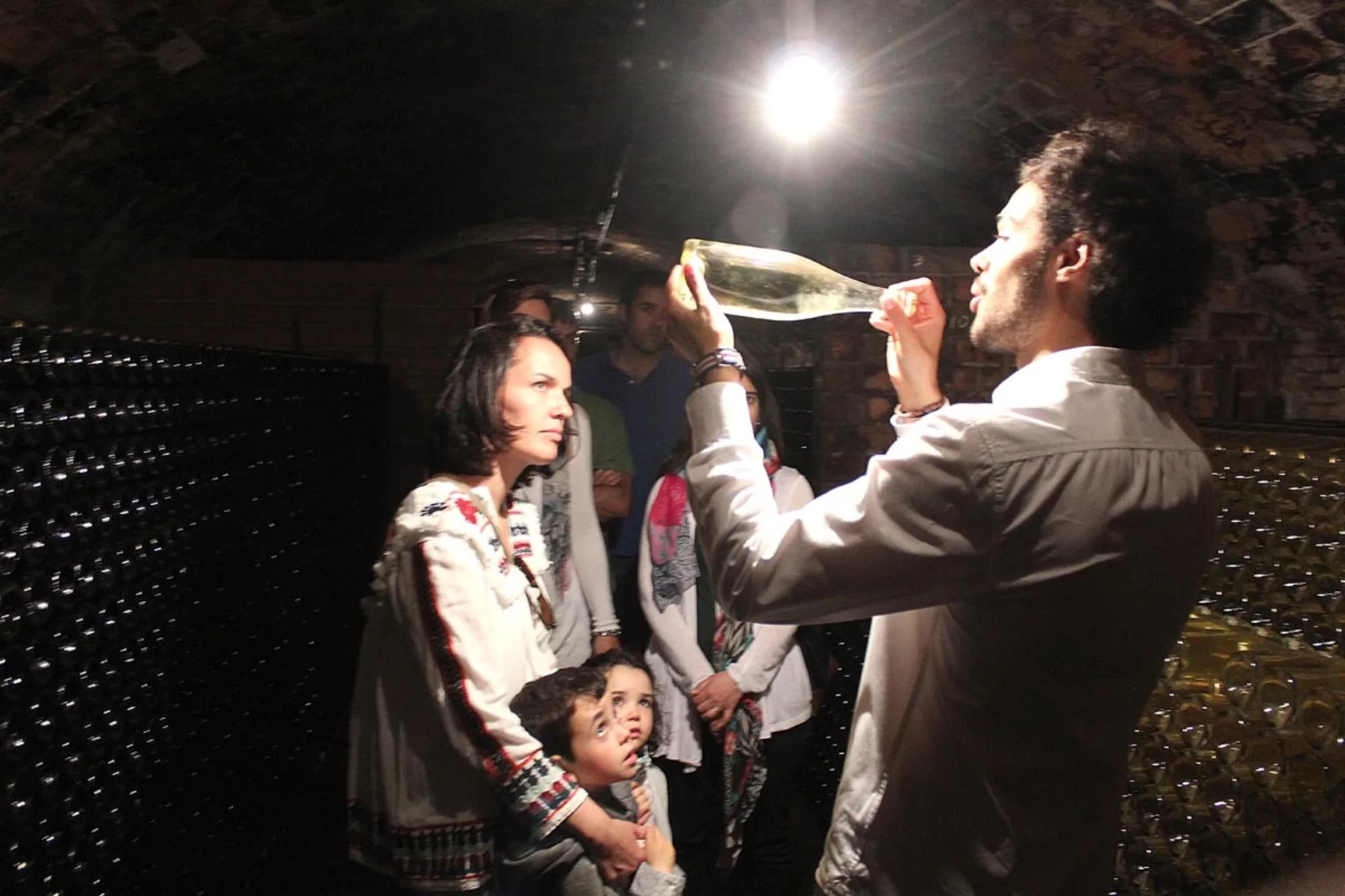Visitants tastant una ampolla a la cava durant la jornada solidària