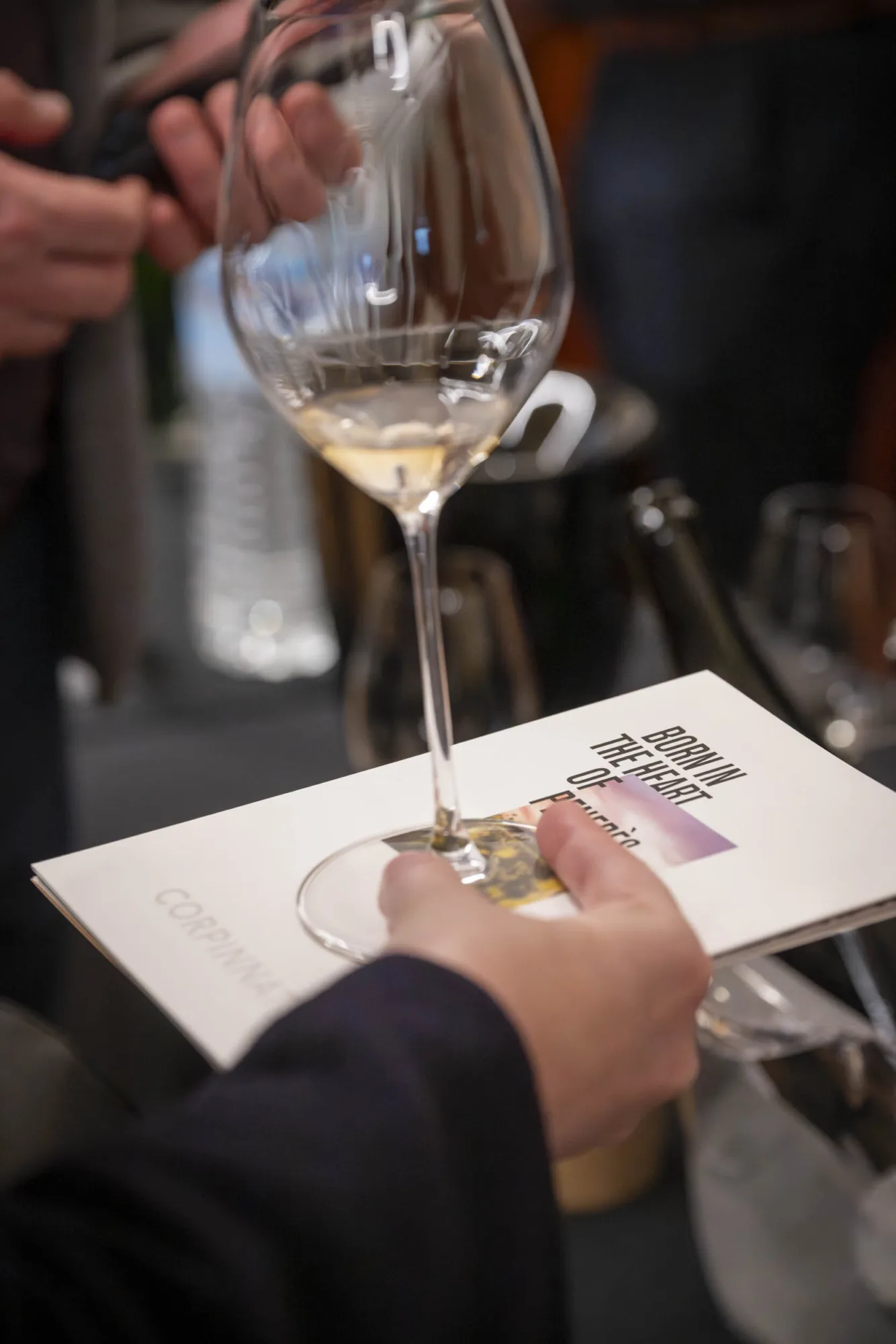 Glass of sparkling wine and tasting sheet at the Corpinnat showroom in the Netherlands