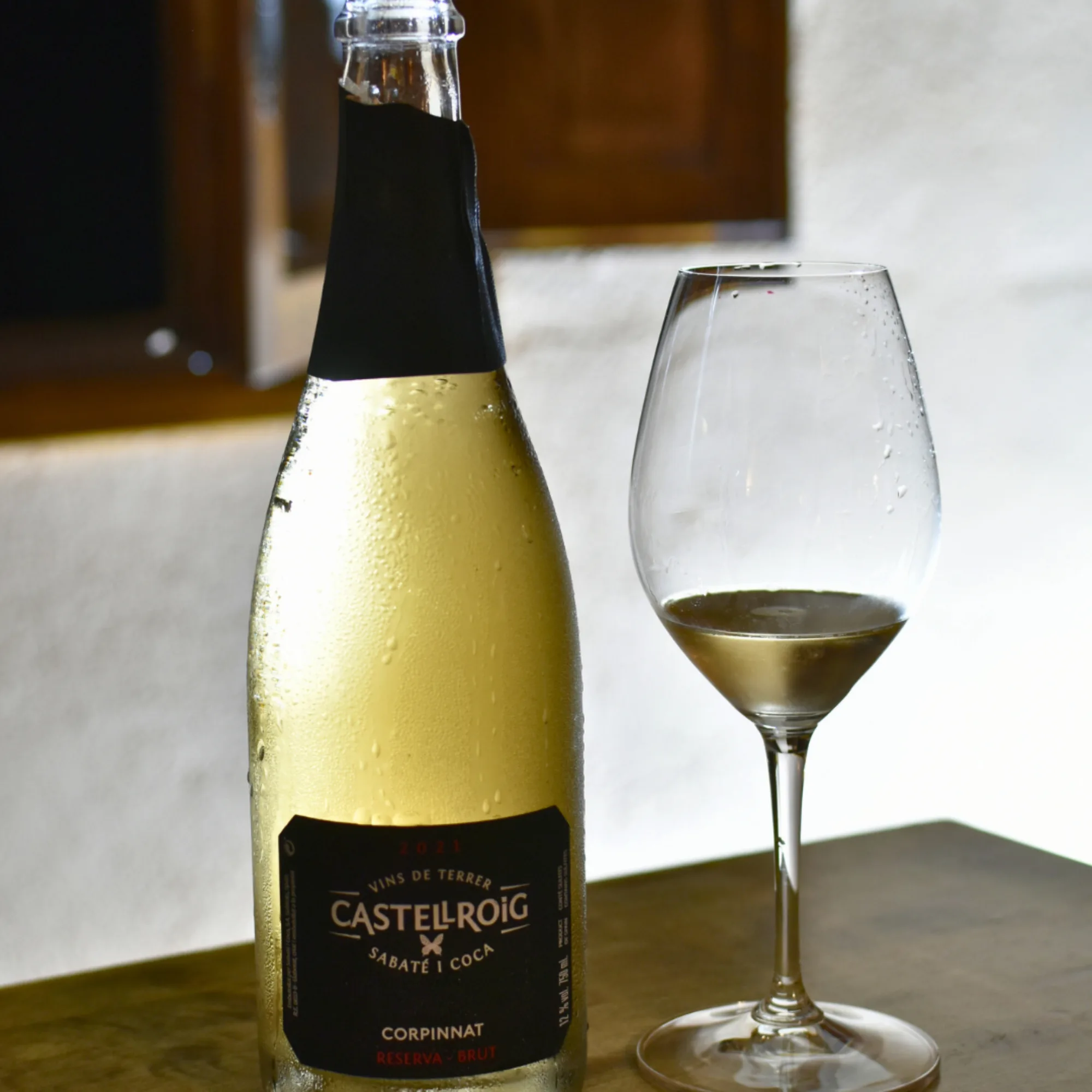 Botella de Castellroig con una copa de espumoso