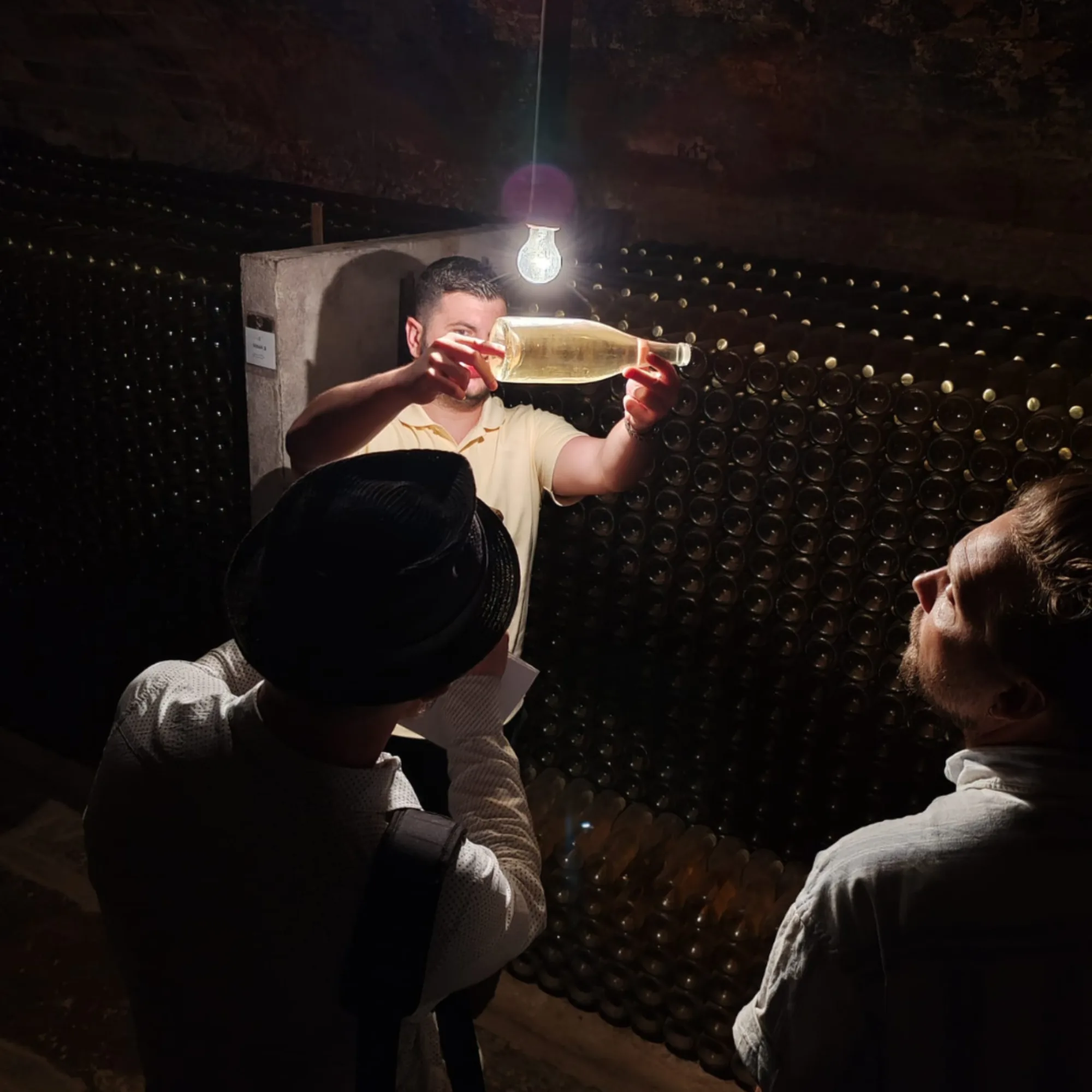 Visitantes observando una botella a contraluz en la cava
