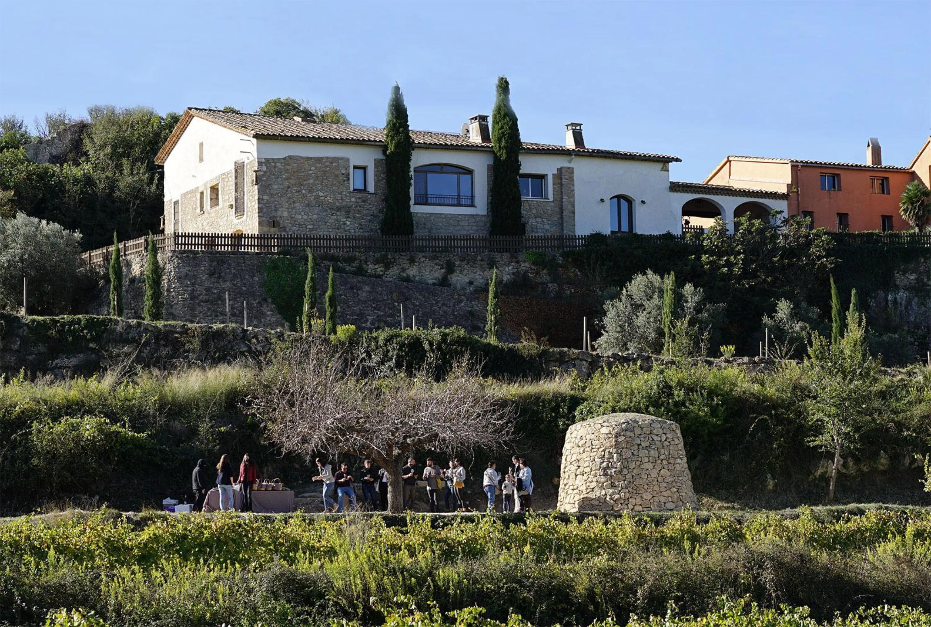 Visitantes entre viñedos y una barraca de piedra seca durante la jornada de puertas abiertas