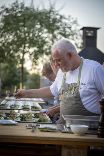 Chef emplatando al aire libre en una cena del Festival Gastronómico